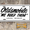Oldsmobile "We Build Them" License Plate